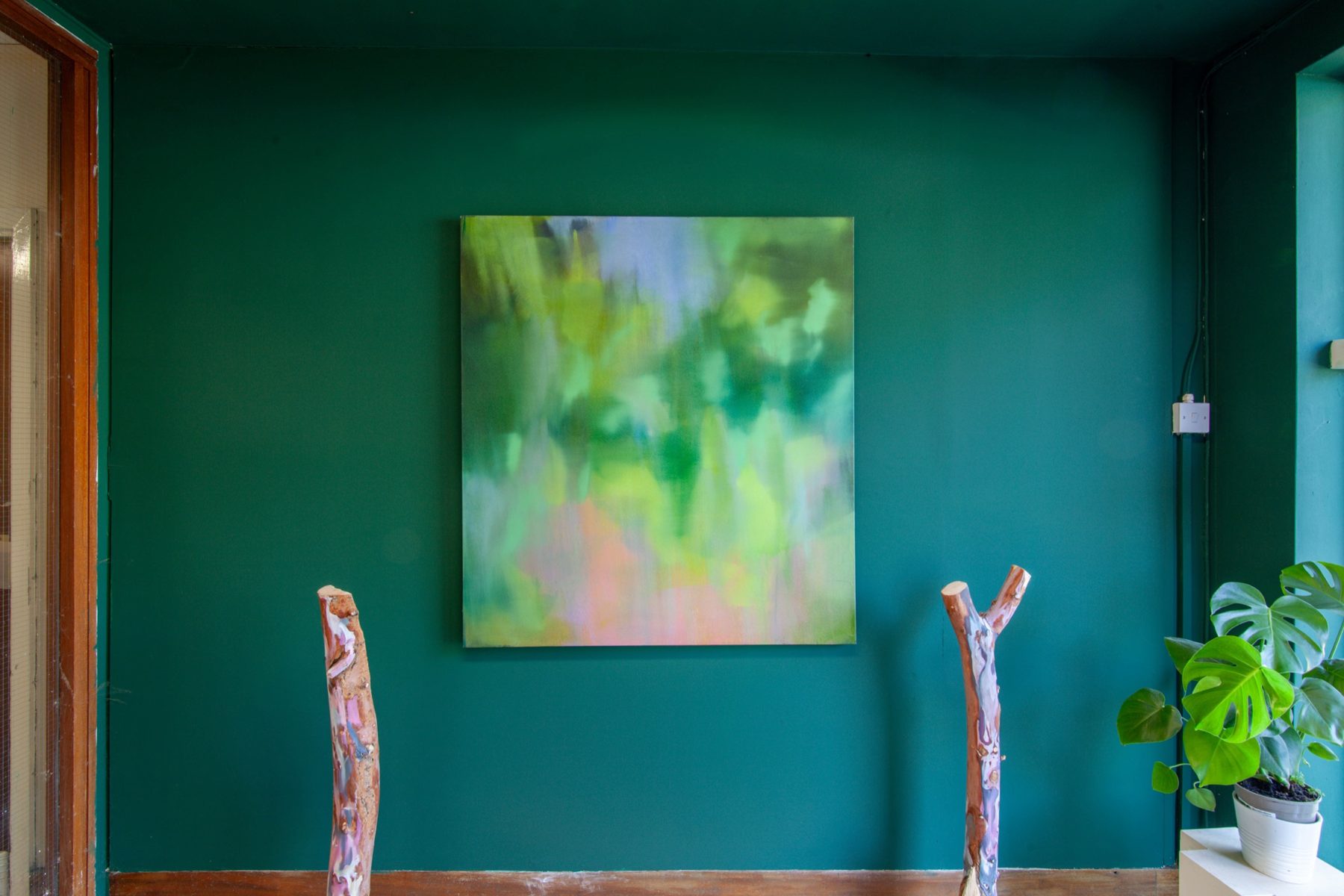 A studio with a green wall and a painting